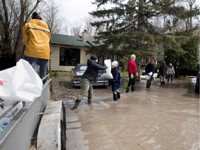 A human chain of volunteers move sandbags to help protect a home in Hudson on May 8, 2017.