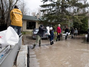 A human chain of friends and volunteers move sandbags to help protect the Calfolia family home in Hudson on Monday May 8, 2017.