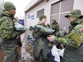 Soldiers stationed in Val Cartier, Qc. stack sandbags around the Larry Cool pumping station, in Deux-Montagnes, northwest of Montreal Monday May 8, 2017.