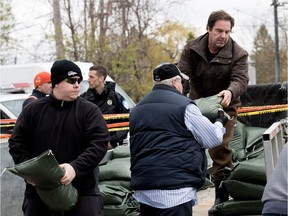 Alain Furlano and neighbours unload sandbags for a dike on 5th Ave. in the Roxboro district of Montreal on Tuesday May 9, 2017. Furlano was later arrested. (Allen McInnis / MONTREAL GAZETTE)