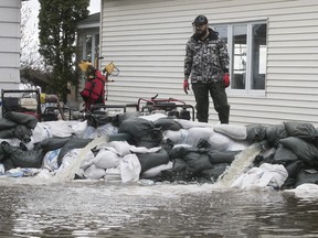 Dave Chartrand checks the efficiency of the pumps around a home on Saint-Jean-Baptiste St. in Oka on Tuesday May 9, 2017.