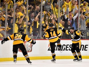 Chris Kunitz (#14) of the Pittsburgh Penguins celebrates with Sidney Crosby (#87) and Ian Cole (#28) after scoring a goal against Craig Anderson (#41) of the Ottawa Senators in the second overtime with a score of 3 to 2 in Game Seven of the Eastern Conference Final during the 2017 NHL Stanley Cup Playoffs at PPG PAINTS Arena on May 25, 2017 in Pittsburgh, Pennsylvania.