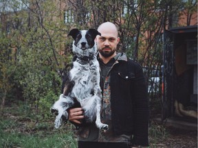 Owner Daniel Pelissier scoops up Abby, the Blue Heeler mix, while some snow fell earlier this week.