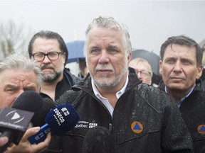 Quebec Premier Philippe Couillard speaks to reporters during a visit to a home surrounded by flood waters in the town of Rigaud, west of Montreal, Saturday, May 6, 2017, following flooding in the region.THE CANADIAN PRESS/Graham Hughes ORG XMIT: GMH117