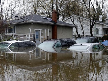 Several cars left in a driveway are filled with water in Gatineau, Que., as rising river levels and heavy rains continue to cause flooding, on Saturday, May 6, 2017.