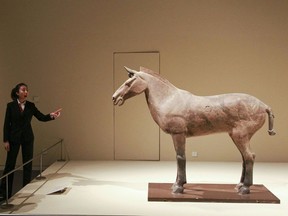 This photo taken on May 16, 2011 shows visitors admiring a clay horse from the Terracotta Warriors from the Qin Dynastry (221BC -206 BC) on display at the Ancient China Exhibition at China's National Museum in Beijing.  The exhibition has a total of 10 halls filled with precious relics from ancient times to the end of Qing Dynasty, showing a complete picture of the continuing development of Chinese civilization. CHINA OUT