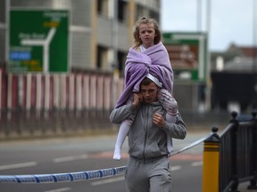 A man carries a young girl on his shoulders near Victoria station in Manchester, May 23, 2017. Twenty two people were killed and dozens injured in Britain's deadliest terror attack in over a decade targeted fans leaving an Ariana Grande concert.