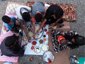 TOPSHOT - A family breaks fast on the first day of the Muslim holy month of Ramadan, at al-Khazir camp for the internally displaced, located between Arbil and Mosul, on May 27, 2017.