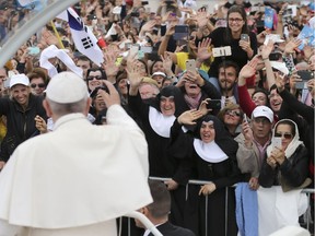 Pope Francis gestures to the crowd at the Sanctuary of Our Lady of Fatima Saturday, May 13, 2017, in Fatima, Portugal. Pope Francis canonized two shepherd children whose visions of the Virgin Mary 100 years ago marked one of the most important events of the 20th-century Catholic Church.
