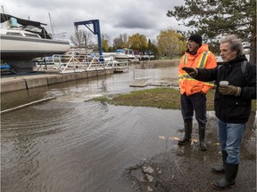 Trevor Collins (in orange) and Barry Barnett check the water levels at the Pointe Claire Yacht Club last month.