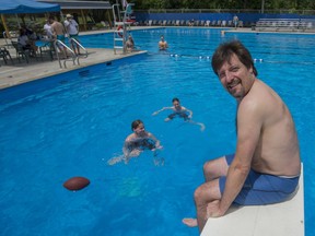 Les Raschkowan sits on one of the diving boards as his children enjoy the coo water of Elm Park Pool in Dollard-des-Ormeaux on Saturday.