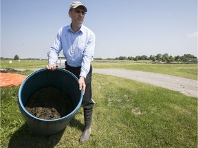 McGill professor Grant Clark displays human waste used as biosolids for fertilizer, on test fields at Macdonald campus on Monday. The federal government is investing in the university to conduct research on greenhouse gas mitigation in agriculture.