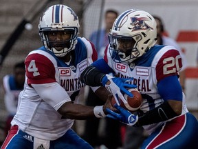 Alouettes quarterback Darian Durant, left, hands off to running-back Tyrell Sutton (20) during first half preseason action Thursday night at Molson Stadium.