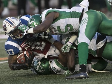Montreal Alouettes's Tyrell Sutton is brought down by members of the Saskatchewan Roughriders's during second quarter action in Montreal onThursday June 22, 2017.