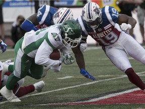 Saskatchewan Roughriders's Bakari Grant his taken down by Montreal Alouettes' Fabion Foote and Travis Hawkins during first- quarter action in Montreal on Thursday June 22, 2017.