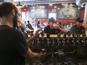 Bartender Yannick Marcoux tends to patrons at Dieu Du Ciel!'s  Laurier Ave. location. The microbrewery's name and beers, like Grande Noirceur, poke fun at Quebec's Roman Catholic heritage. "As a small brewery, we're free to do that sort of thing," says co-founder Jean-François Gravel.