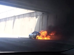 A flaming car is seen on the Décarie Expressway in Montreal on June 26, 2017.