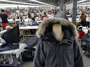 Employees signed the first winter coat produced at the new Canada Goose factory in Boisbriand.