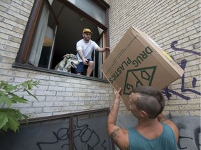 MONTREAL, QUE.: JULY 1, 2016 --  Francis LaPierre, in window, takes a box from Dan Walfish as they move into their new apartment in Montreal during Quebec's traditional moving day Friday, July 1, 2016. (Peter McCabe / MONTREAL GAZETTE) ORG XMIT: 56608

Friday, July 1, 2016 at 12:00:31 PM
Peter McCabe, MONTREAL GAZETTE