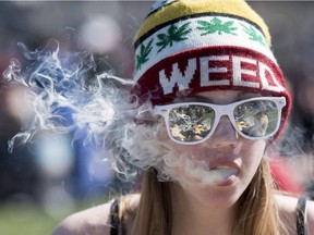 A woman exhales while smoking a joint during the annual 420 marijuana rally on Parliament hill on Wednesday, April 20, 2016, in Ottawa.