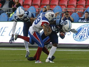 Alouettes linebacker Dominique Tovell pulls down Argonauts running-back James Wilder Jr. during preseason CFL action on Thursday, June 8, 2017.