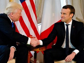 US President Donald Trump (L) shakes hands with French President Emmanuel Macron ahead of a working lunch, at the US ambassador's residence, on the sidelines of the NATO summit, in Brussels, on May 25, 2017.