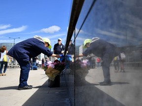 Photo of the day: A woman stops to look at flowers left by well-wishers on London bridge in London on June 11, 2017, following the June 3 terror attack that targeted members of the public on London Bridge and Borough Market. Fake suicide vests worn by the assailants in the London Bridge attack were made with disposable water bottles attached to leather belts, police revealed Sunday.