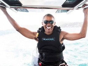 In a recent handout picture released by Virgin on February 7, 2017, former US president Barack Obama is pictured during a kitesurfing session with British billionaire Richard Branson, off the coast of Moskito Island in the British Virgin Islands in the Caribbean. /