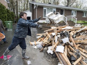 May 14, 2017 - David Samuelson throws debris from his flooded house in the Pierrefonds borough of Montreal.