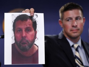 Timothy Wiley, FBI public affairs specialist, holds a photo Amor Ftouhi after a news conference in Detroit, June 22, 2017.