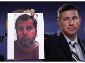 Timothy Wiley, FBI public affairs specialist, holds a photo Amor Ftouhi after a news conference in Detroit, June 22, 2017.