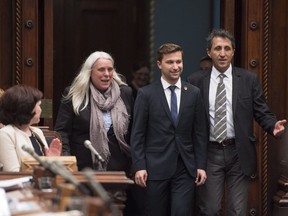 Quebec Solidaire MNA Gabriel Nadeau-Dubois enters the National Assembly, escorted by Quebec Solidaire MNA Manon Masse, left, and Amir Khadir, right, on Tuesday.
