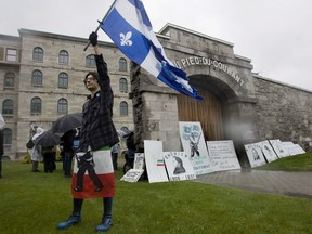 A man holds up a Quebec flag at the former Pied-du-Courant Prison prior to embarking on a march in east end Montreal to mark the Journée nationale des Patriotes Monday, May 19, 2008.
