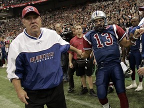 Alouettes head coach Don Matthews helps quarterback Anthony Calvillo to his feet after Calvillo failed to get a first down on the last play of the second overtime at the 2005 Grey Cup in Vancouver.