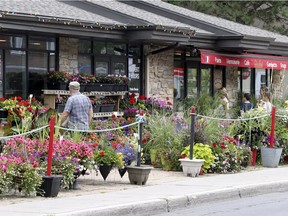 Customers enter the bakery/coffee shop, right, while a man heads into the flower market on Lakeshore Drive in Dorval last Thursday.