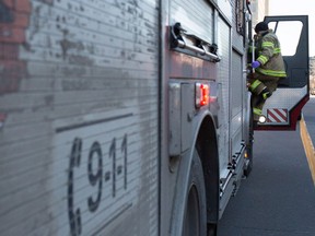 MONTREAL, QUE.: DECEMBER 30, 2014-- A Montreal fireman from Station 5 climbs into his truck after responding to a person in distress call in Montreal on Tuesday December 30, 2014. Station 5 is Canada's busiest fire station and the firemen were needed to help paramedics load the patient into a waiting ambulance. (Allen McInnis / MONTREAL GAZETTE)