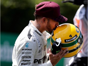 Lewis Hamilton of Mercedes Petronas kisses Ayrton Senna's helmet after being presented with the helmet for equalling Senna's record for pole positions after Hamilton captured the pole during qualifying at the Canadian Formula 1 Grand Prix at Circuit Gilles Villeneuve in Montreal on Saturday June 10, 2017.