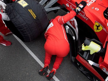 Sebastian Vettel of Ferrari looks under the hood of his car as he arrives on the starting grid during the Canadian Formula 1 Grand Prix at Circuit Gilles Villeneuve in Montreal on Sunday, June 11, 2017.