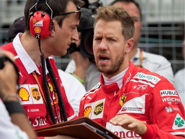 Sebastian Vettel of Ferrari speaks with a crew member after looking under the hood of his car on arriving on the starting grid during the Canadian Formula 1 Grand Prix at Circuit Gilles Villeneuve in Montreal on Sunday, June 11, 2017.