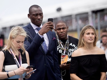 Montreal tennis star Eugenie Bouchard, right, and NBA player Bismack Biyombo take part in the starting grid ceremony during the Canadian Formula 1 Grand Prix at Circuit Gilles Villeneuve in Montreal on Sunday, June 11, 2017.