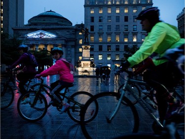 Cyclists brave the rain as the ride through Place d'Armes during the Tour de nuit in Montreal on Friday, June 2, 2017.