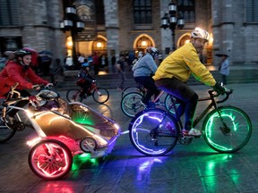Cyclists pedal past Notre-Dame Basilica during the Tour la Nuit on June 2, 2017.