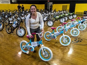 Sun Youth staff member Sarah-Jean Raymond helps set up giveaway bicycles in 2017.