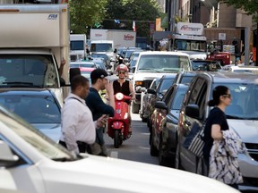 A scooter inches its way through traffic downtown as Grand Prix activities begin.