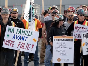 Constructions workers picket outside the entry of the Champlain Bridge construction site after they walked off the job in Montreal on Wednesday, May 24, 2017.