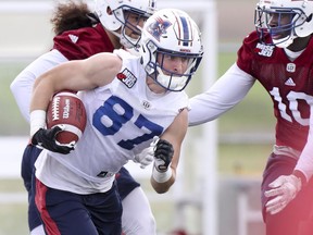 Reciever Danny Anthrop runs away from linebacker Anthony Sarao, rear, and safety Chris Ackie during Alouettes training camp at Bishops University.
