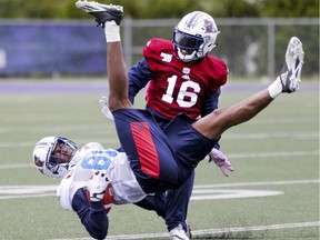 Wide receiver Devon Bailey is upside down after making a leaping catch in front of defensive back Ronald Tyler during the Montreal Alouettes training camp at Bishop's University in Lennoxville, southeast of Montreal Monday May 29, 2017.