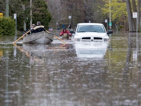 Residents row past an abandoned pick-up truck on 5th Ave. N. in the Roxboro district of Montreal on Tuesday, May 9, 2017.