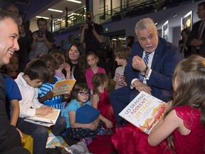 Quebec Premier Philippe Couillard chats with young students at a news conference to unveil new policies on education, Wednesday, June 21, 2017 in Quebec City.