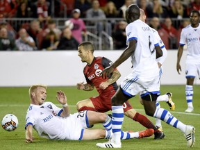 Montreal Impact defender Kyle Fisher (26) makes a sliding tackle on Toronto FC forward Sebastian Giovinco (10) as Montreal Impact defender Hassoun Camara (6) looks on during second half Canadian Championship soccer action in Toronto on Tuesday, June 27, 2017.